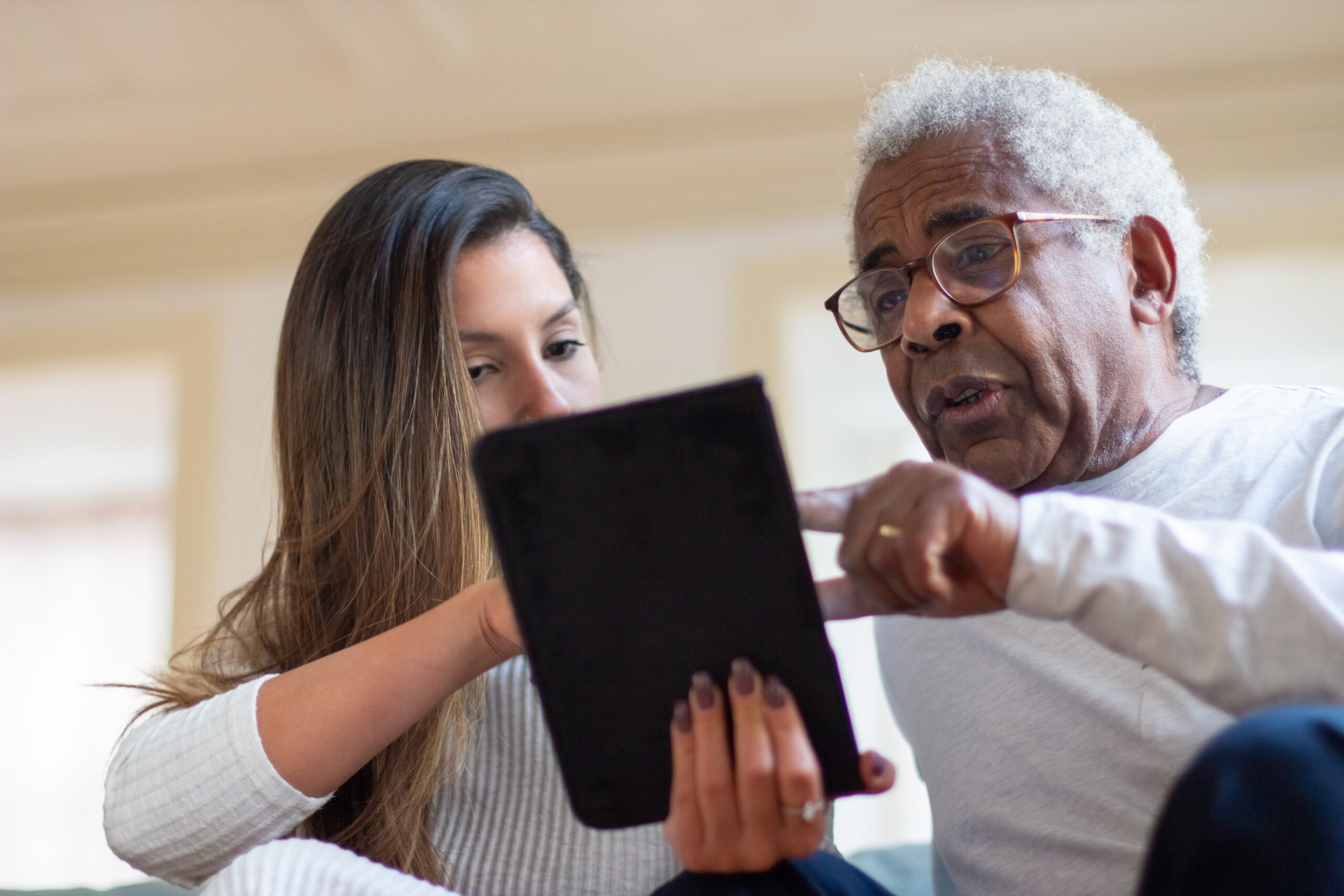 An aging man and his Direct Care Professional using a tablet to record services via Electronic Visit Verification