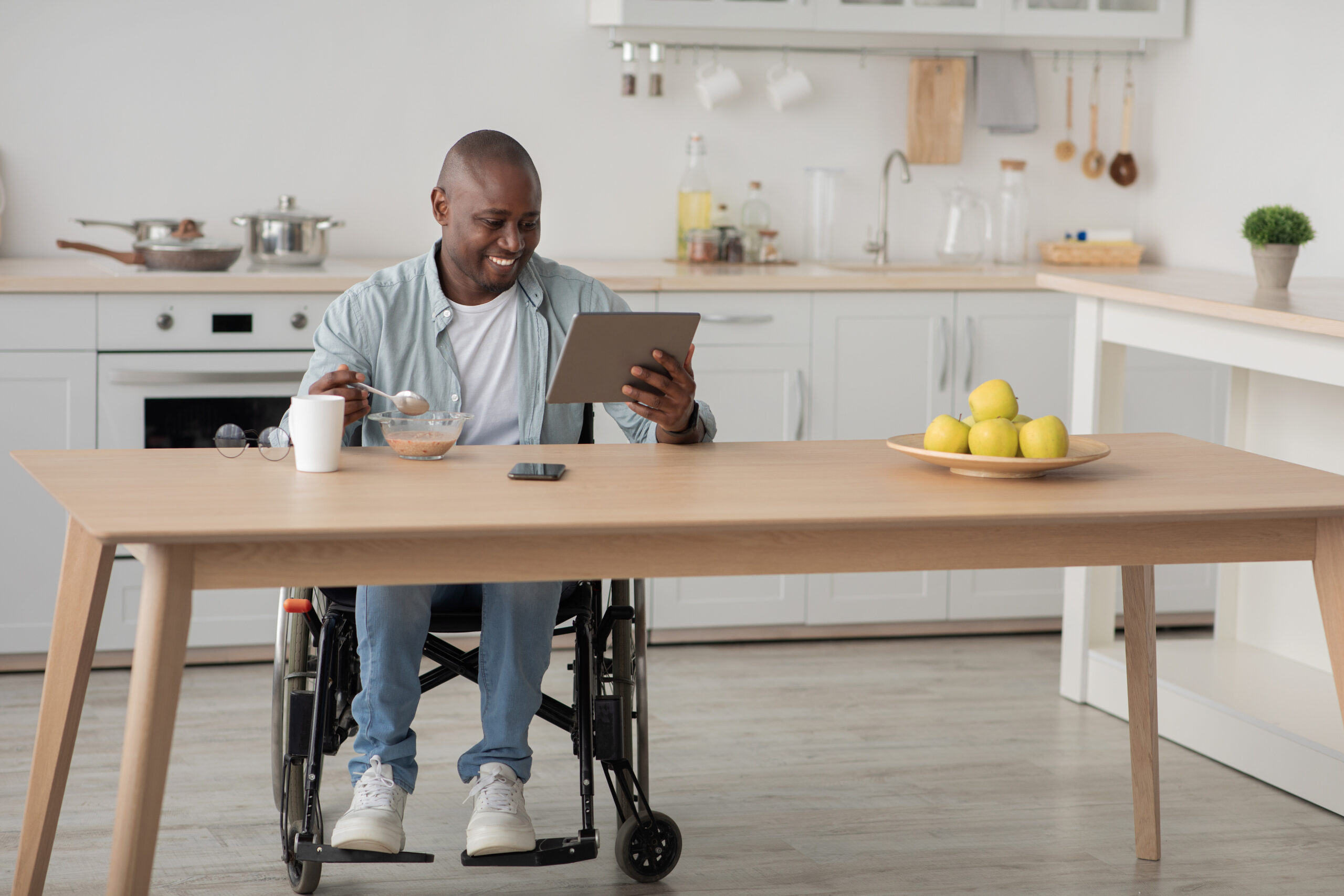 Man in a wheelchair using his tablet to record a EVV records from his home on the CareTime Mobile App